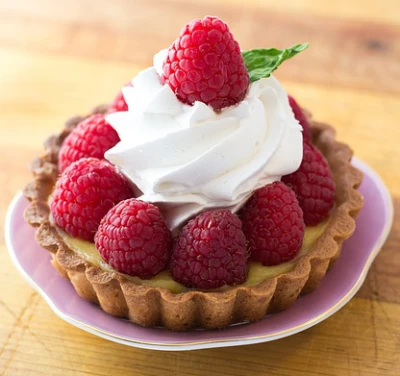 pastry custard tart topped with raspberries and cream